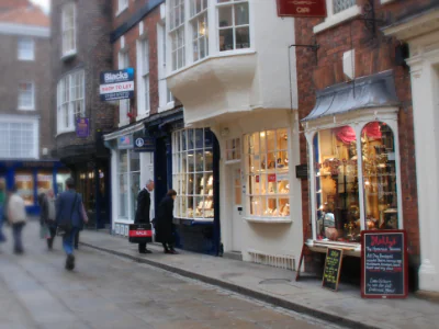 Pyramid Gallery's window glows in it's white front on Stone Gate, York